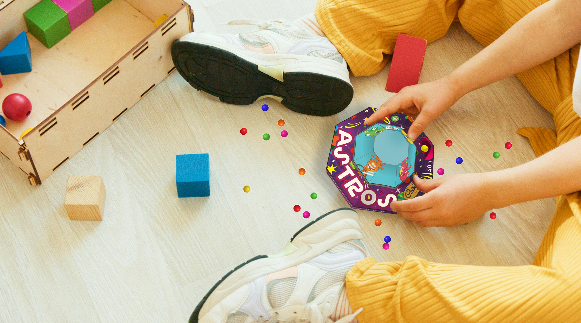 A child sitting on the floor and playing with the Astros redesigned packaging
